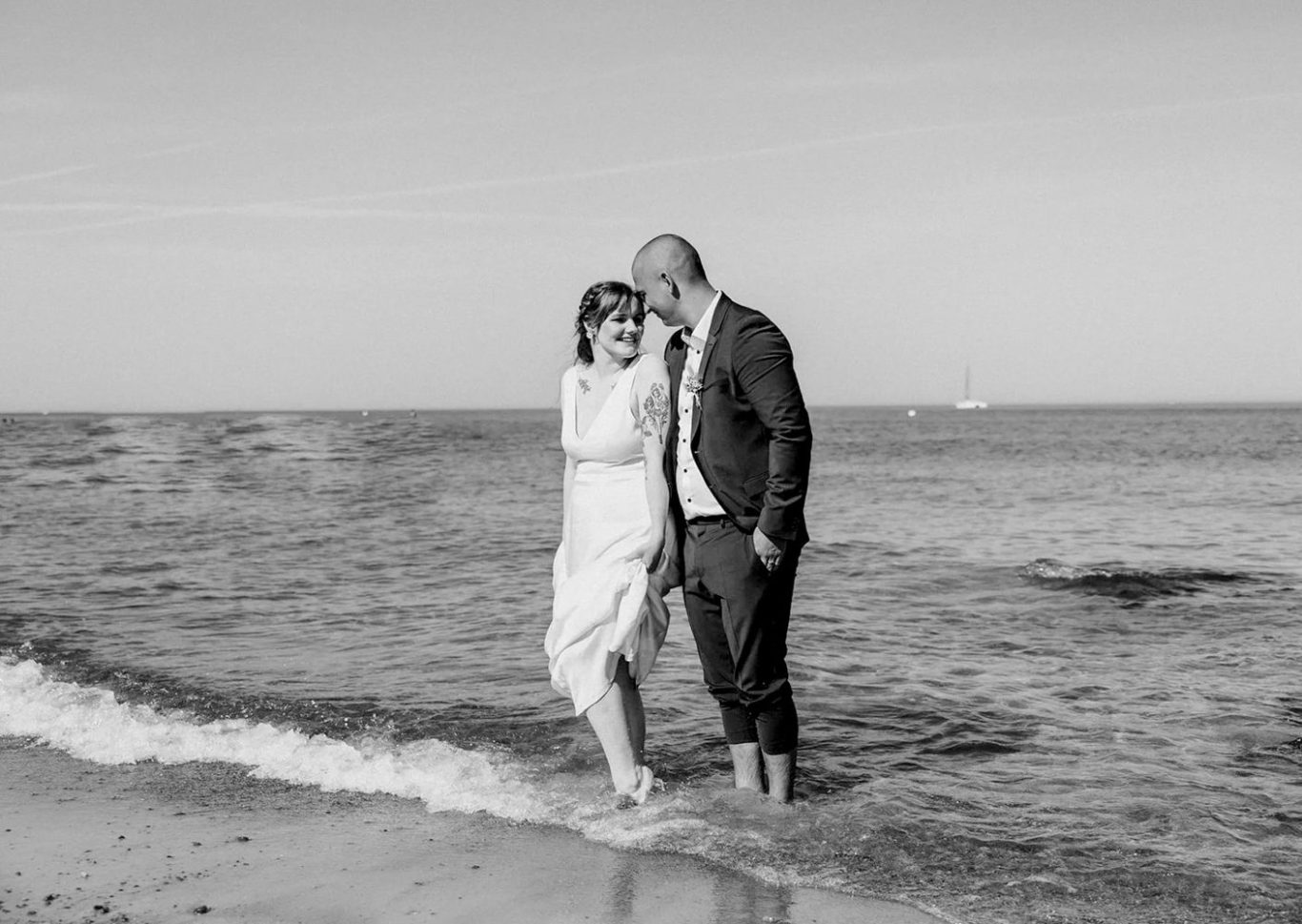 Hochzeitfotos Strand Kühlungsborn Hochzeitspaar am Strand von Kühlungsborn mit den Füßen im Meer.